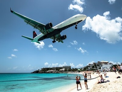 A large plane lands just feet over people at Maho Beach in St Maarten.