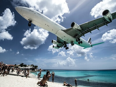 A large plane lands just feet above the beach in St Maarten.